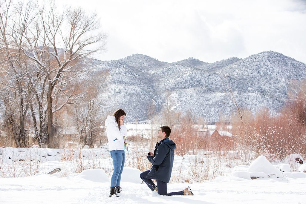 Dan kneels in the snow as he proposes to Elizabeth in Basalt, CO.