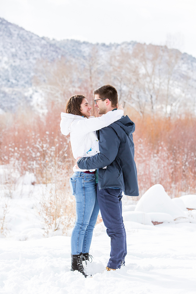 Dan and Elizabeth are surrounded by snow near the Roaring Fork River after he proposes.