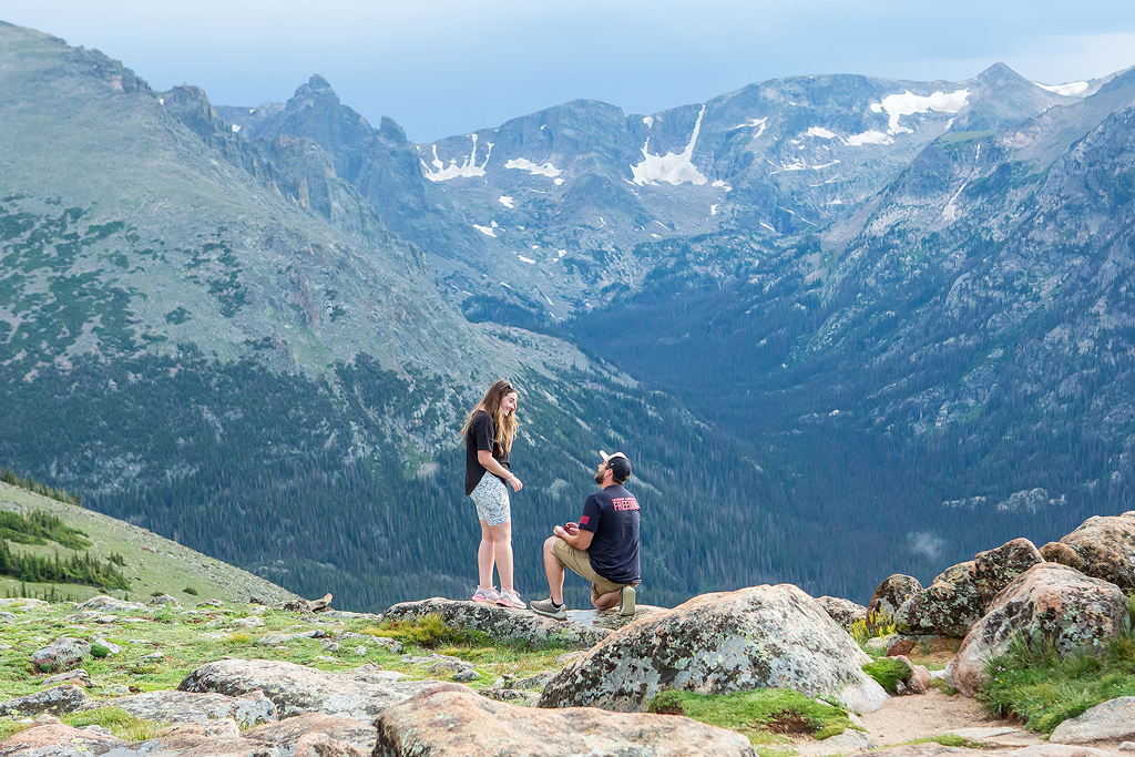 Zach kneels to propose on Trail Ridge Road in Rocky Mountain National Park, CO.