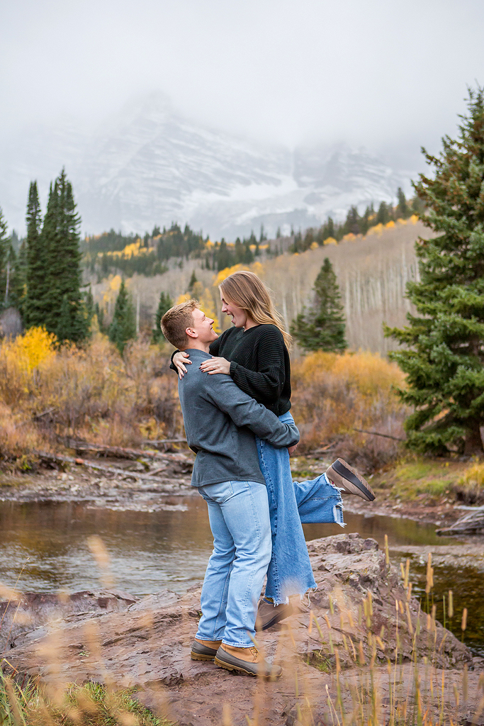 Jackson picks up Claire in front of Maroon Bells on a fall day during their engagement.