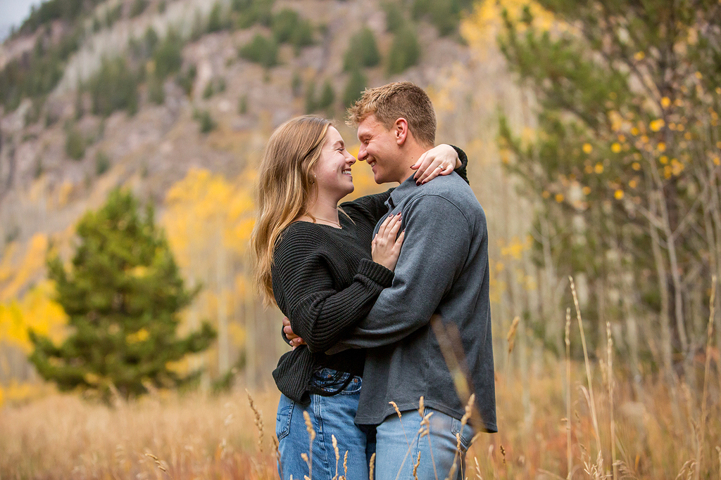 Jackson and Claire snuggle surrounded by trees after he proposes near Aspen Colorado.