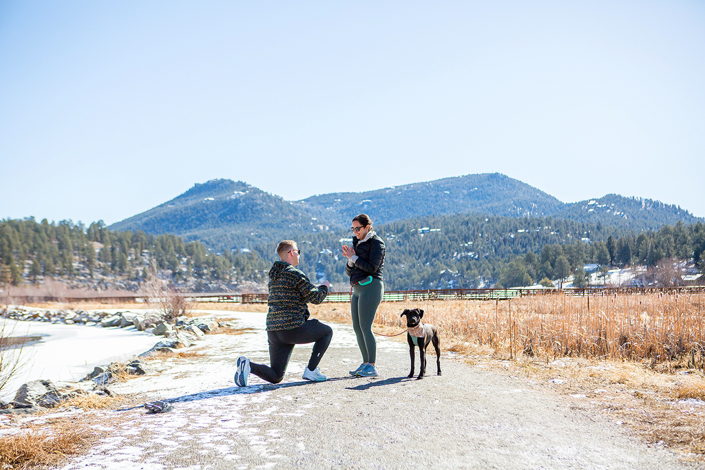 Ryan kneels in front of a Colorado mountain backdrop to propose to Alissa at Evergreen Lake.