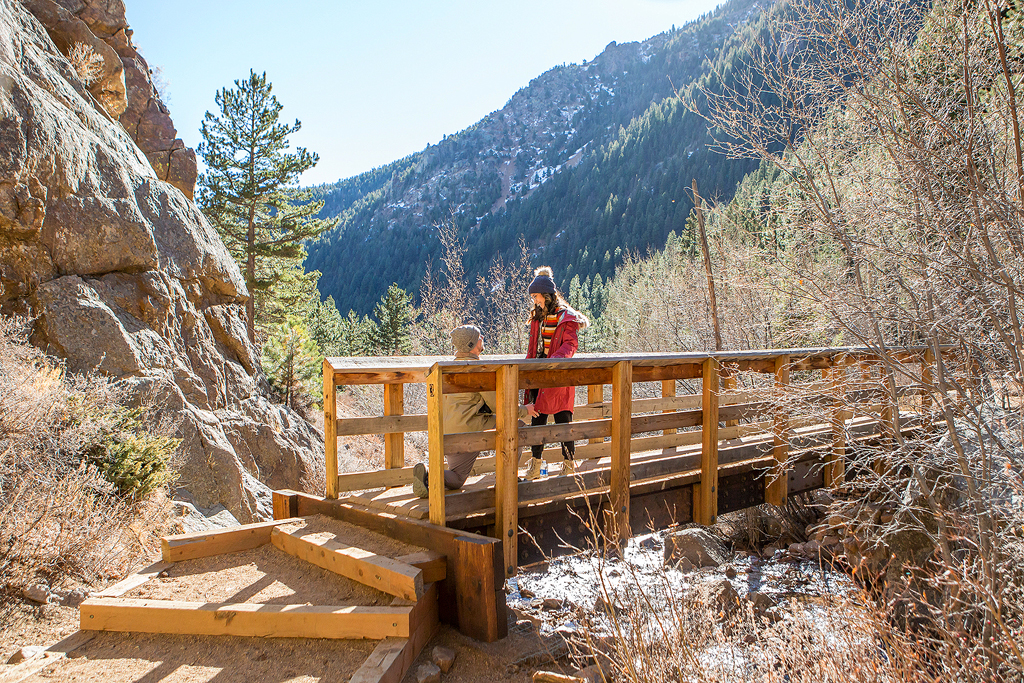 Carlos kneels on a bridge in Cheyenne Canyon as he proposed to Juliana in Colorado.