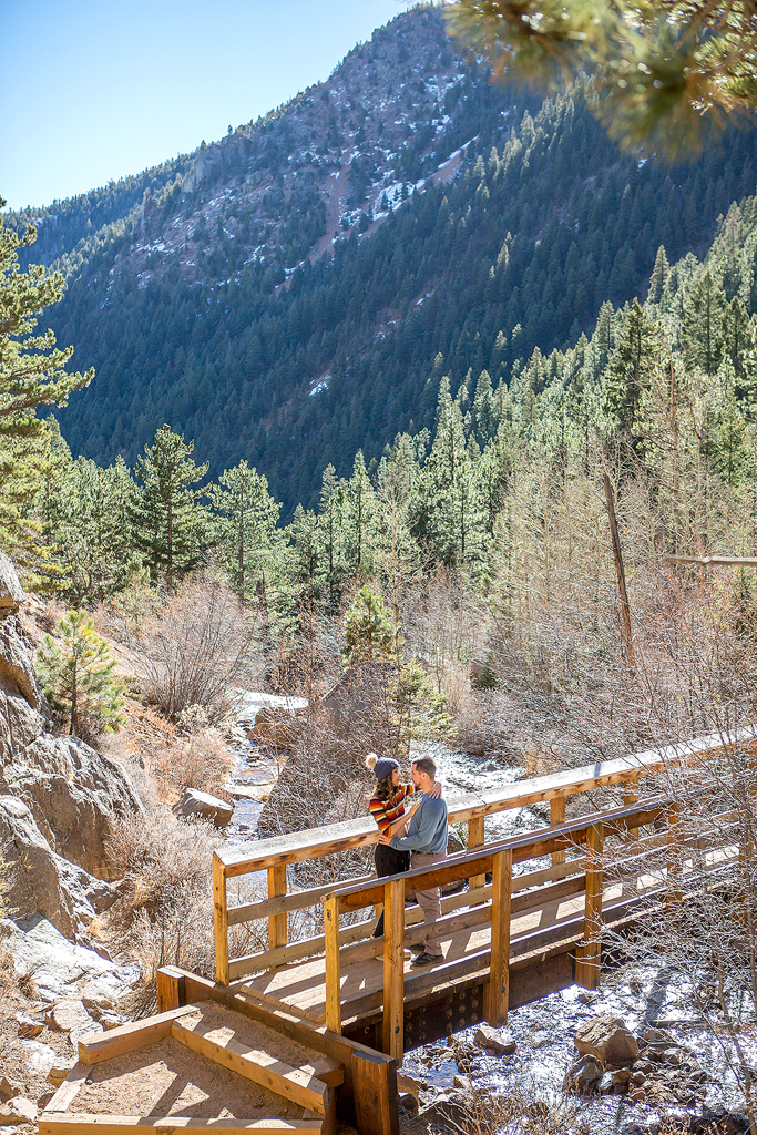 Carlos and Juliana on the bridge with the creek and mountains behind them in Cheyenne Canyon.