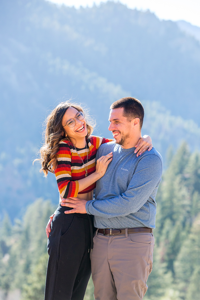 Juliana laughs with mountains behind her in Carlos’ arms after he proposes in Colorado.