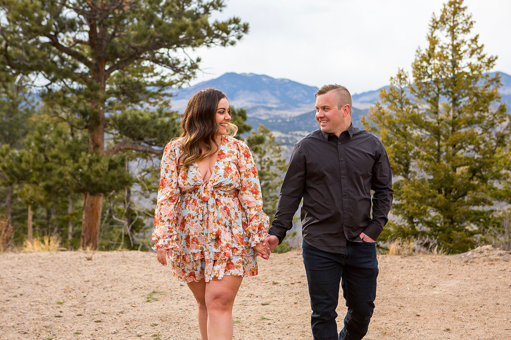 Garrett and Marissa hold hands in front of a mountain view near Golden, Colorado.