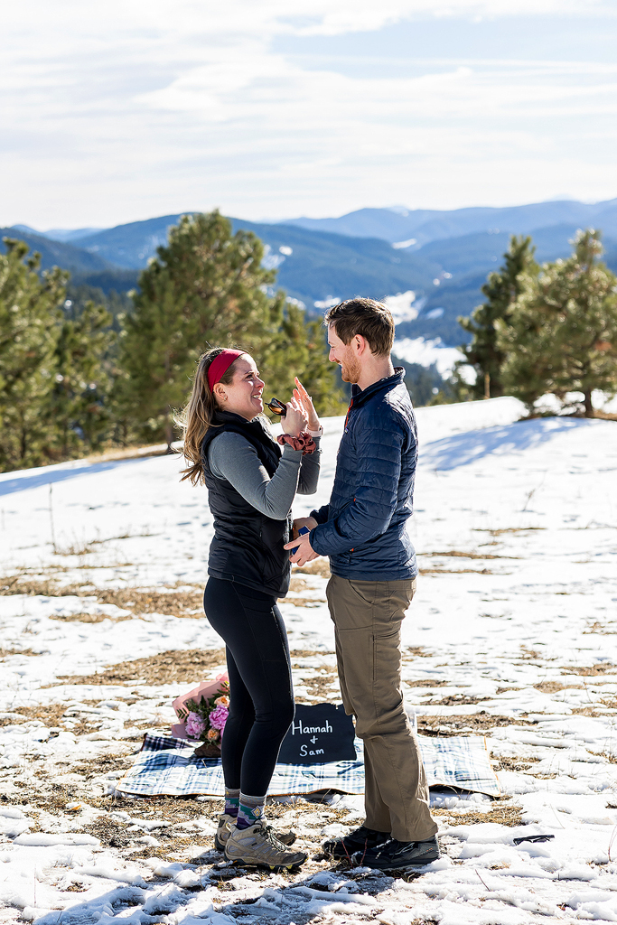 Hannah's reaction of surprise after Sam proposed in Colorado at Mount Falcon West Park.