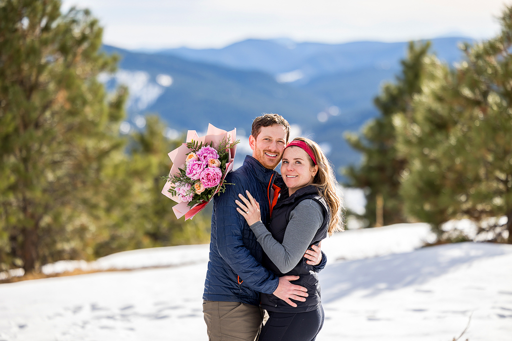 Hannah and Sam with a bouquet of flowers after Sam proposed to her at Mount Falcon Park.