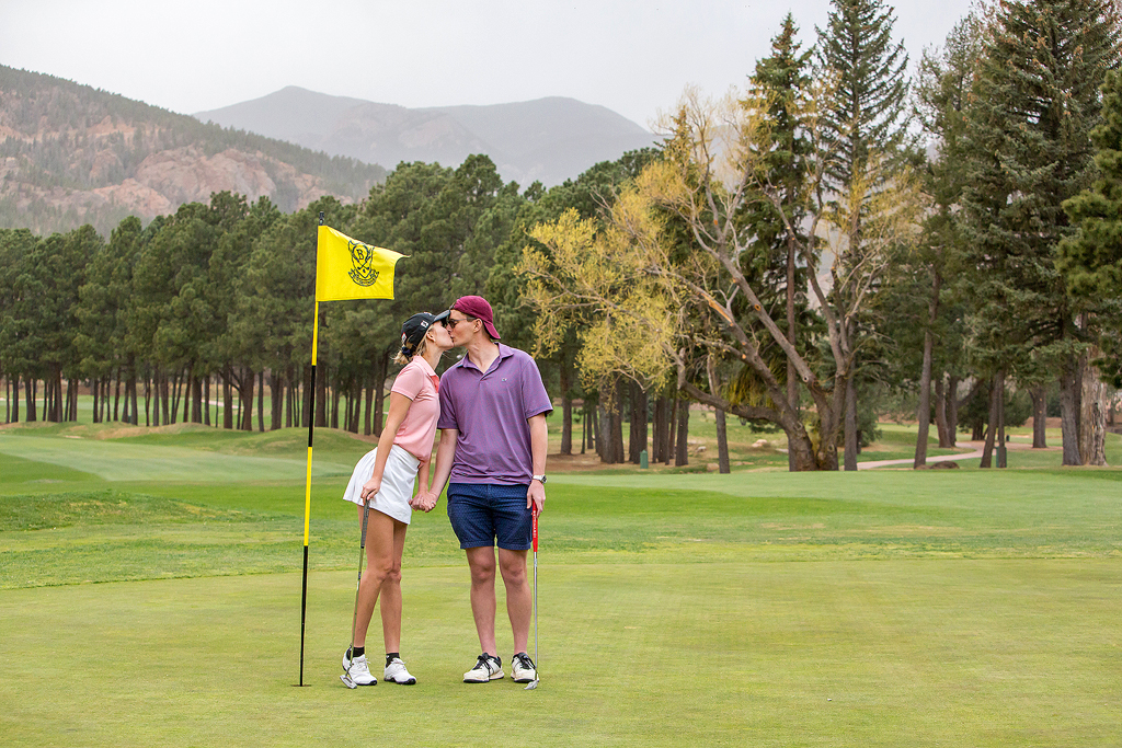 Matt and Morgan kiss near a flag on the 18th hole after their surprise proposal in Colorado.