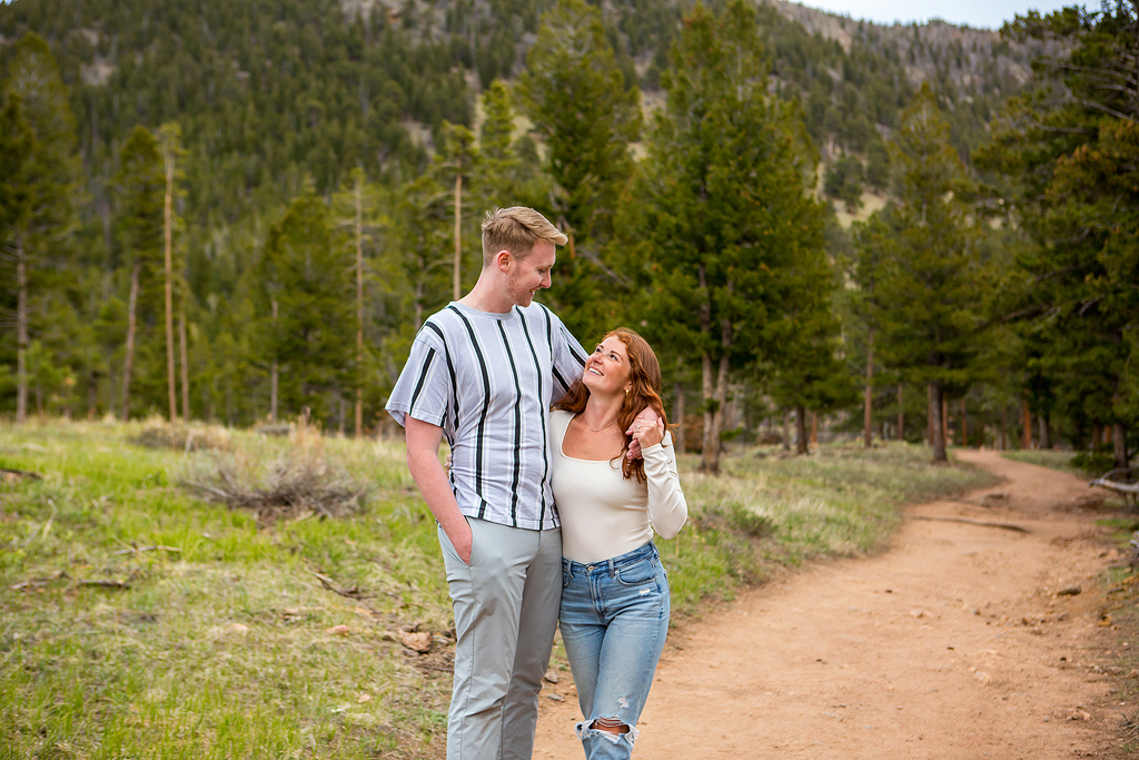 Noah and Lea walk on a trail in Rocky Mountain National Park after their surprise proposal in Colorado.