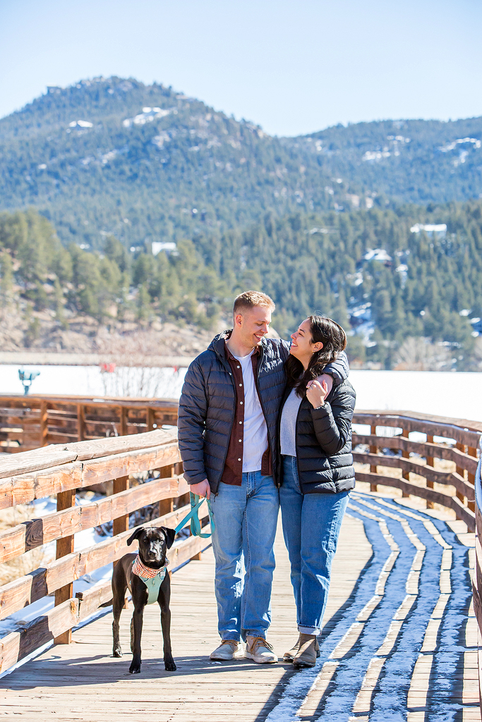 Ryan and Alissa on a wooden boardwalk around Evergreen Lake with their dog during their engagement.