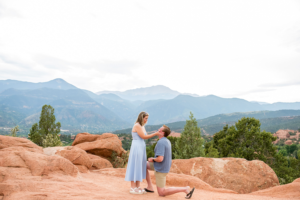Stephen kneels in front of Jenna as he proposes at Garden of the Gods in Colorado.