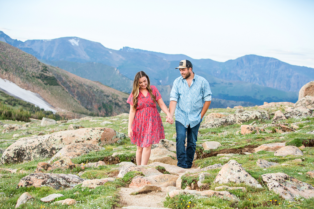 Zach and Sabrina walk holding hands on a trail over the continental divide in RMNP.