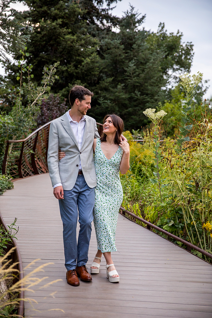 Couple walks together on a wooden walkway after their proposal at Denver Botanic Gardens.