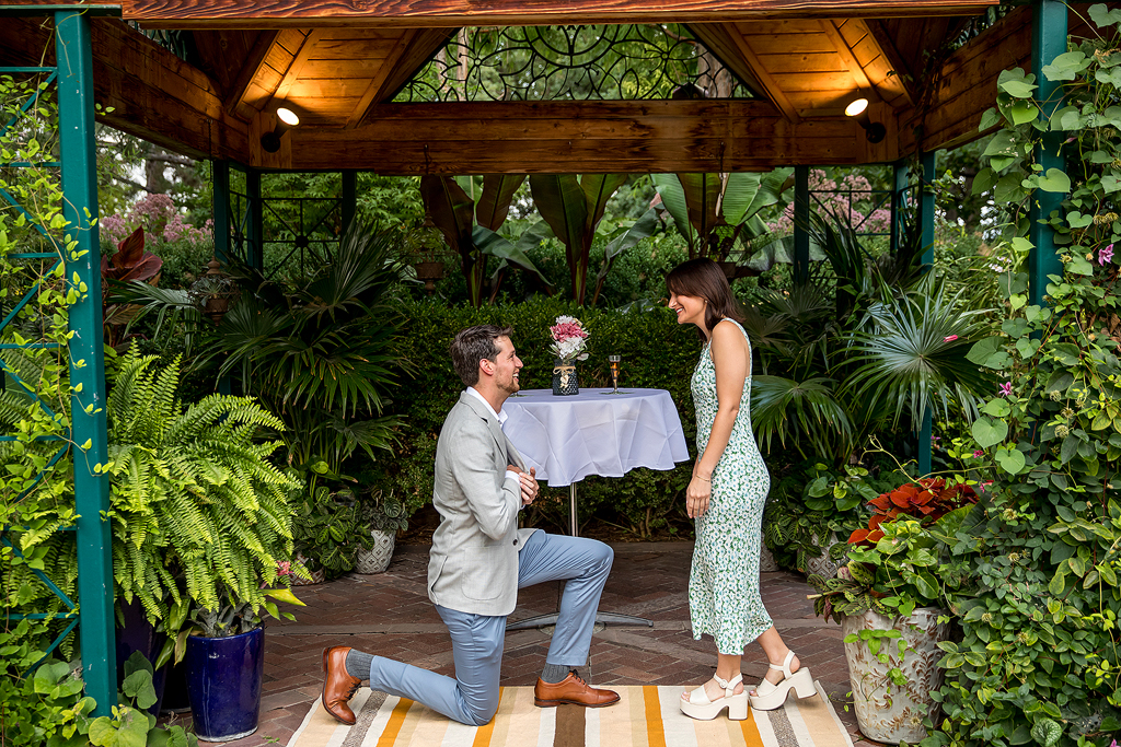 Conor kneels to propose in front of a private event space at Denver Botanic Gardens