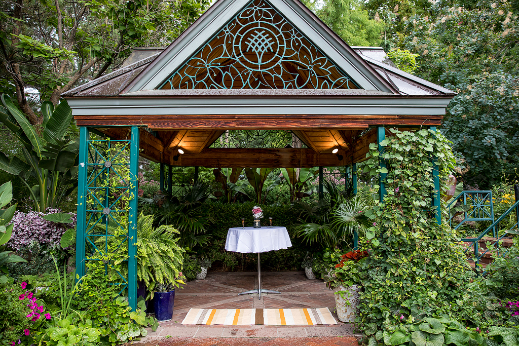 Proposal location at Denver Botanic Gardens with table, rug, flowers and champagne right in the Victorian Secret Garden.