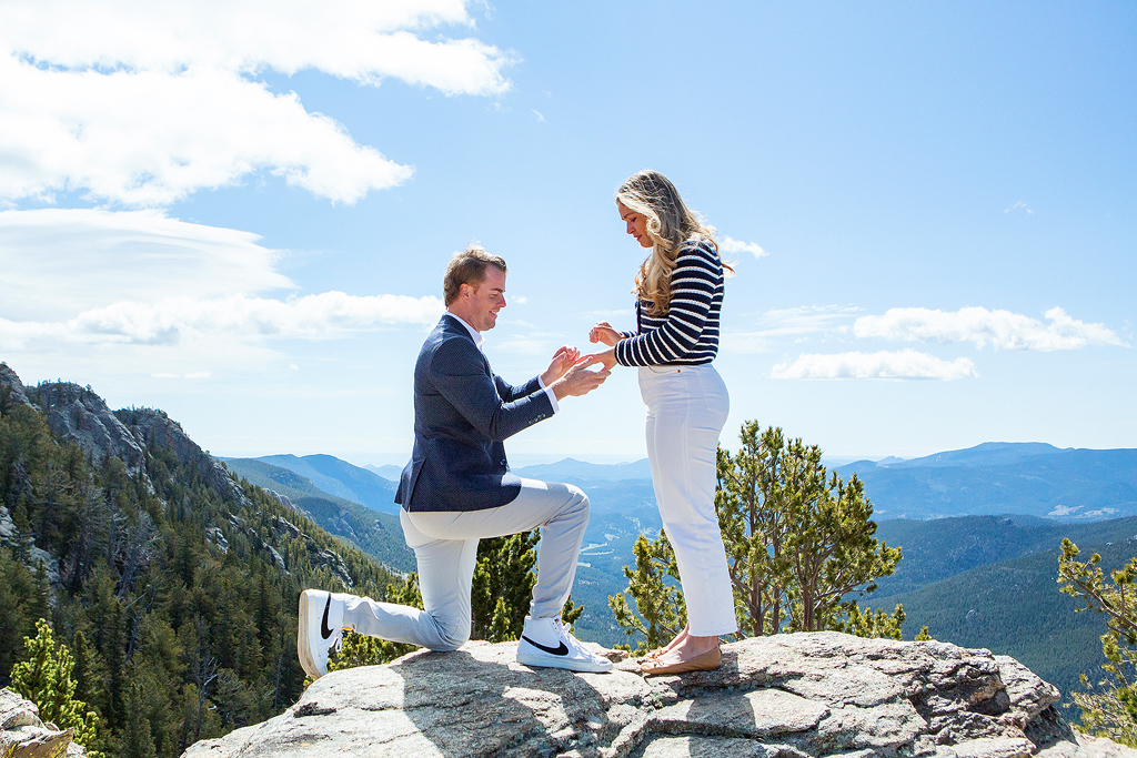 Ed puts the ring on Savanah's hand during this Juniper Pass proposal on top of rocky cliffs.