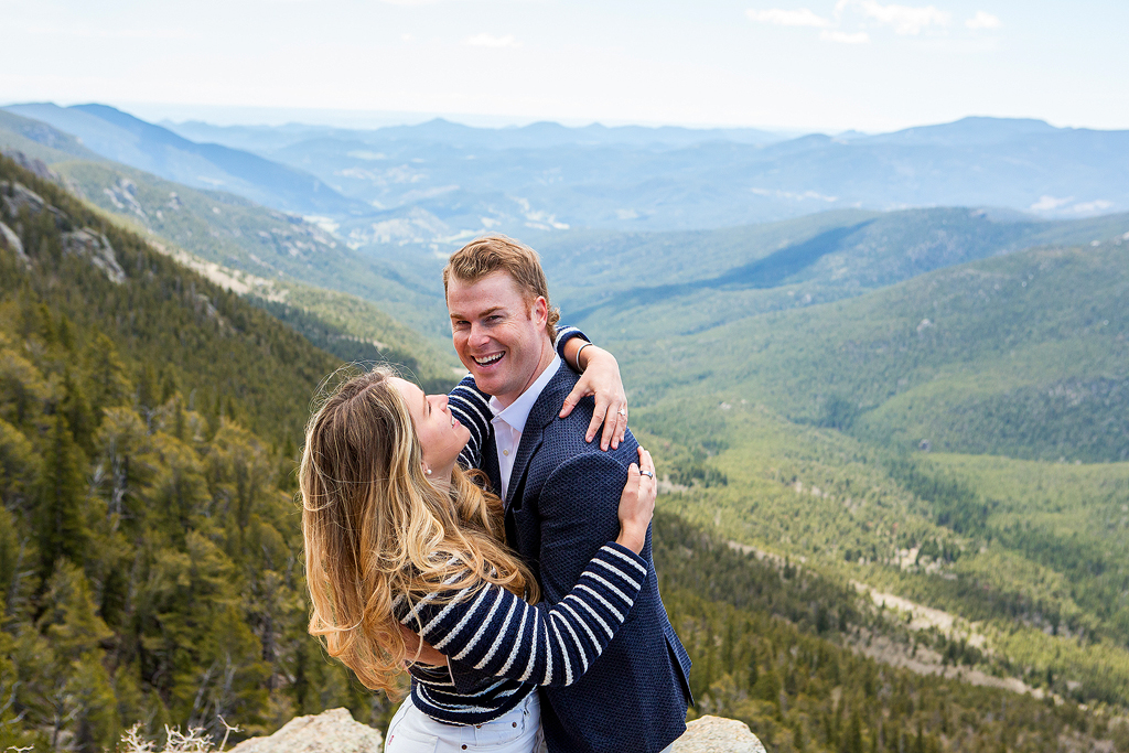 Savanah wraps her arms around Ed with the mountains of Juniper Pass behind them.
