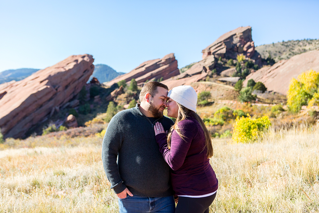 Cory and Samantha snuggle during their proposal at Red Rocks Park with the rock formations behind them.